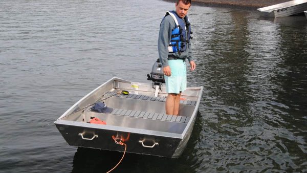 Adult standing in the jon 10, with a view of the two handles and bow clip